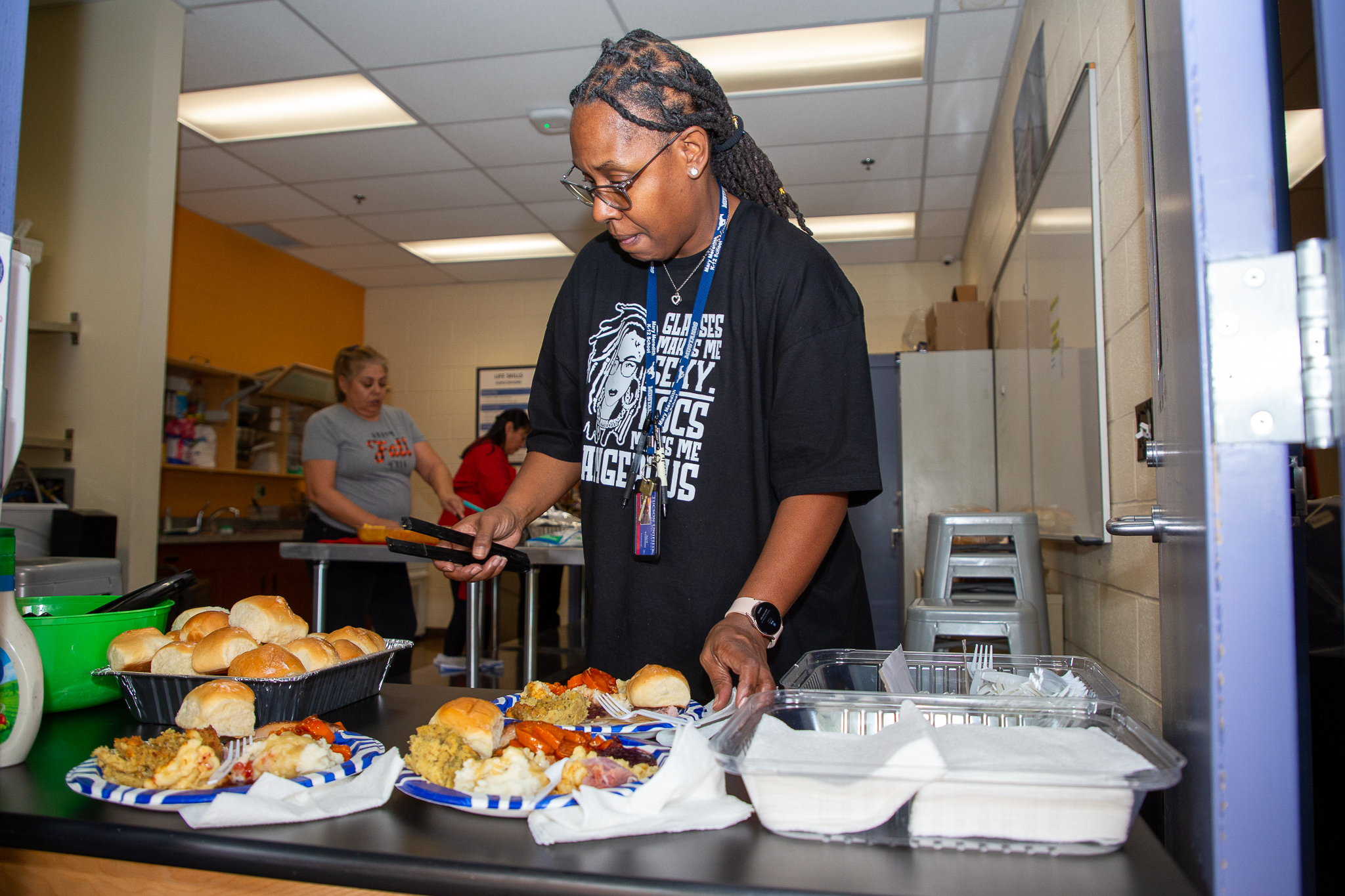 A woman dishes up Thanksgiving food for students and staff