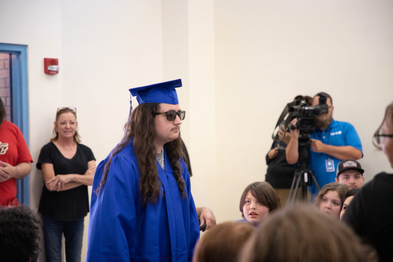 A Mary Meredith grad walks into the ceremony in his cap and gown