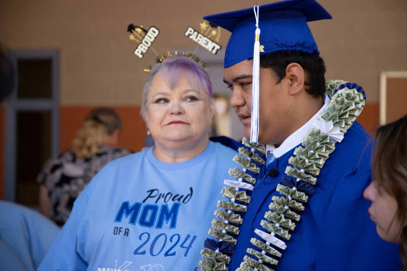 A Mary Meredith grad stands next to his mom after the ceremony