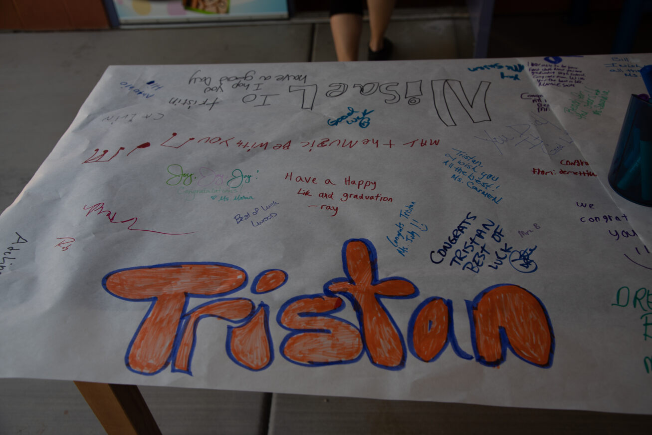 Students wrote messages on a banner for the graduating students